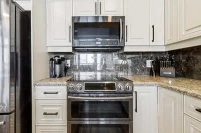 a kitchen with a stove and a microwave at 2BR Slopeside in Chateau Ridge Blue Mountains in Blue Mountains