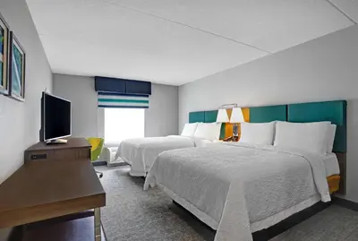 a hotel room with two beds and a flat screen tv at Hampton Inn & Suites Belleville in Belleville