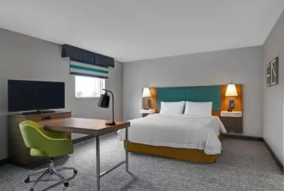 a bedroom with a bed and a desk and a television at Hampton Inn & Suites Belleville in Belleville
