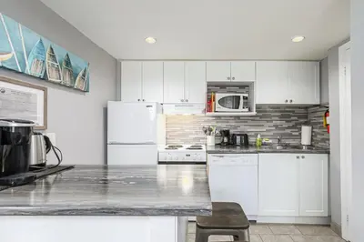 a kitchen with white cabinets and a white refrigerator at Blue Mountain Hideaway at North Creek Resort in Blue Mountains
