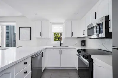 a white kitchen with white cabinets and a sink at Ski in Ski Out Condo at Blue Mountain Close to Village in Blue Mountains