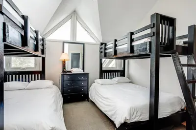 a bedroom with two bunk beds and a window at 2 Bdrm Ski In Ski Out Loft at Blue Mountain in Blue Mountains