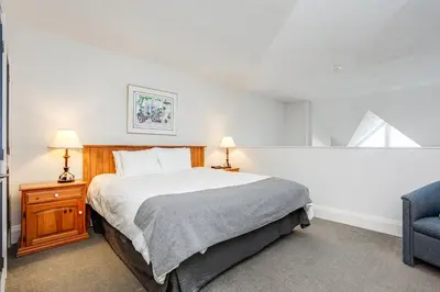 a bedroom with a bed and a blue chair at 2 Bdrm Ski In Ski Out Loft at Blue Mountain in Blue Mountains