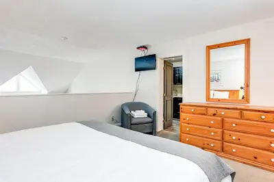 a bedroom with a bed and a dresser and a mirror at 2 Bdrm Ski In Ski Out Loft at Blue Mountain in Blue Mountains