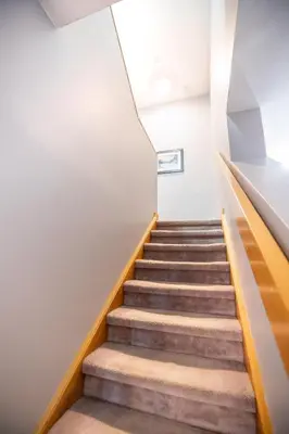 a staircase in a building with wooden railings at Blue Mountain Slopeside Chalet in Chateau Ridge in Blue Mountains