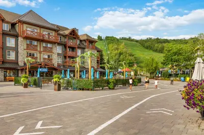 a group of people walking in a plaza in front of a building at Blue Mountain Slopeside Chalet in Chateau Ridge in Blue Mountains
