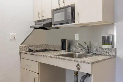 a kitchen with a sink and a microwave at Studio 6 Toronto - Mississauga with Kitchenettes in Mississauga