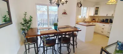 a kitchen with a wooden table and stools at Boho Cottage - Hot tub and close to Beach in Fort Erie