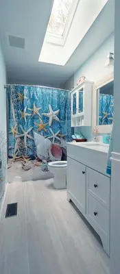 a bathroom with a sink and a toilet and a window at Boho Cottage - Hot tub and close to Beach in Fort Erie