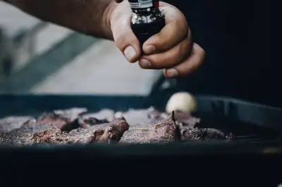 a person holding a bottle of beer above a steak at Boho Cottage - Hot tub and close to Beach in Fort Erie