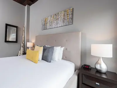 a bedroom with a bed and a lamp on a table at Muskoka Bay Resort in Gravenhurst