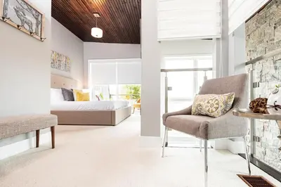 a bedroom with a bed and a chair in a room at Muskoka Bay Resort in Gravenhurst