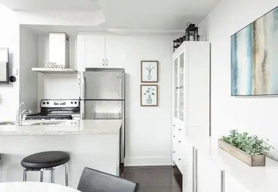 a kitchen with white cabinets and a stainless steel refrigerator at Muskoka Bay Resort in Gravenhurst