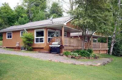 a small house with a large deck on a yard at Ogopogo Resort in Carnarvon