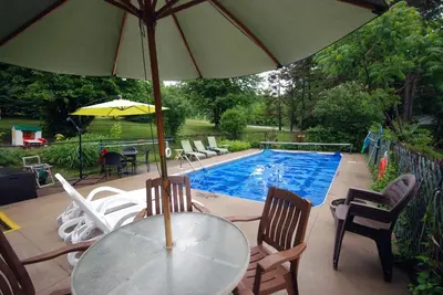 a table with an umbrella next to a swimming pool at Ogopogo Resort in Carnarvon