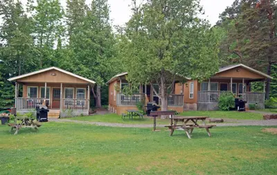 a group of lodges with picnic tables in the grass at Ogopogo Resort in Carnarvon
