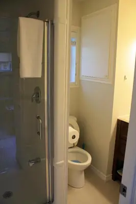 a bathroom with a toilet and a glass shower at Ogopogo Resort in Carnarvon