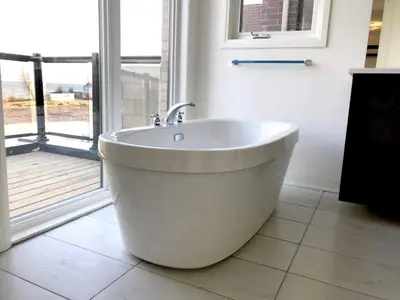 a white bath tub in a bathroom with a window at Grand Waterfront Retreat under 1hr from Toronto in Bowmanville