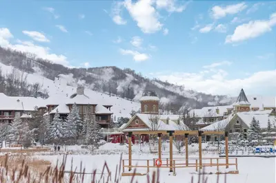 a lodge in the snow with a mountain in the background at Ski In Out 1 BR, Sleeps 6 Cachet Crossing in Blue Mountains