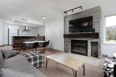 a living room with a couch a table and a fireplace at Ski In Out 1 BR, Sleeps 6 Cachet Crossing in Blue Mountains