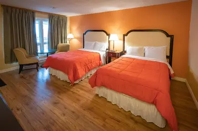 a hotel room with two beds with orange walls at Choice Inn by the falls in Niagara Falls