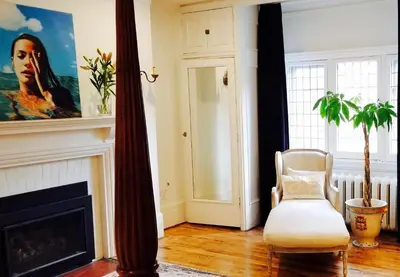 a living room with a chair and a fireplace at The Jane Toronto in Toronto