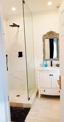 a shower in a bathroom with a sink and a mirror at The Jane Toronto in Toronto