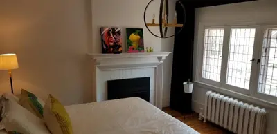 a bedroom with a fireplace and a white bed at The Jane Toronto in Toronto