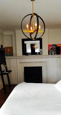 a bedroom with a fireplace and a chandelier at The Jane Toronto in Toronto