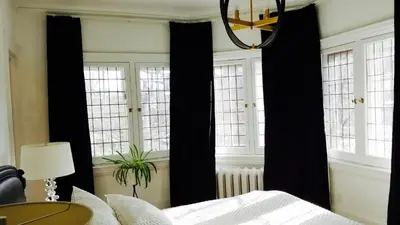 a bedroom with black curtains and a bed at The Jane Toronto in Toronto
