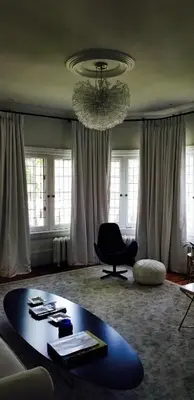 a living room with a table and a chandelier at The Jane Toronto in Toronto