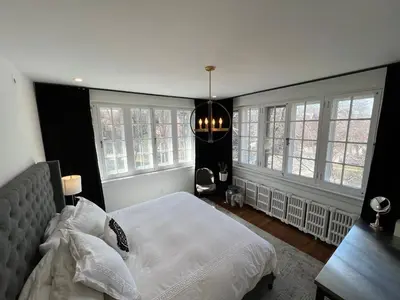 a bedroom with a white bed and windows at The Jane Toronto in Toronto