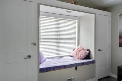 a window seat with pillows on it in a room at Sandy Cove Cottage in Crystal Beach