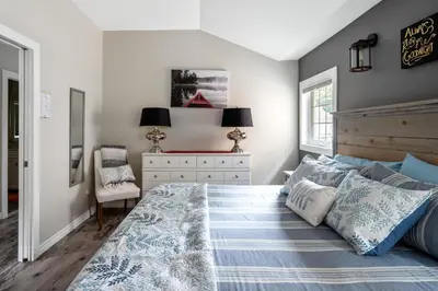 a bedroom with a large bed and a dresser at Sandy Cove Cottage in Crystal Beach