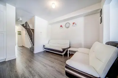 a living room with white furniture and a staircase at Executive Town Home-Mountain View-Historic Snowbridge Village, Walking Distance to the Resort in Collingwood
