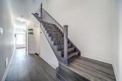 a staircase in a home with wooden floors at Executive Town Home-Mountain View-Historic Snowbridge Village, Walking Distance to the Resort in Collingwood