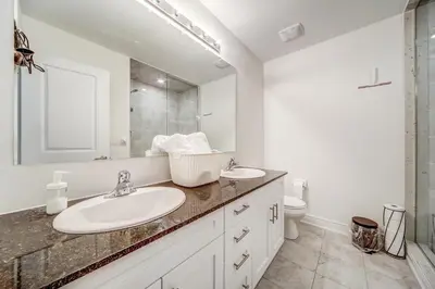 a bathroom with a sink and a mirror and a toilet at Executive Town Home-Mountain View-Historic Snowbridge Village, Walking Distance to the Resort in Collingwood