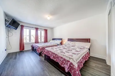 a bedroom with two beds and a flat screen tv at Executive Town Home-Mountain View-Historic Snowbridge Village, Walking Distance to the Resort in Collingwood