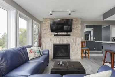 a living room with a blue couch and a fireplace at Condo at Blue Mountain on Ski Run Close to Village in Blue Mountains