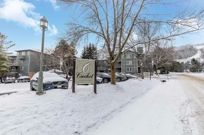 a dealership sign in the snow next to a street at Condo at Blue Mountain on Ski Run Close to Village in Blue Mountains