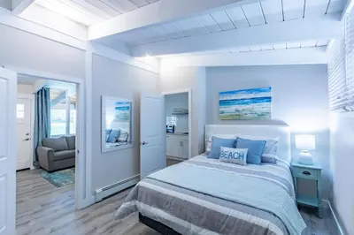 a white bedroom with a bed and a chair at Boutique Suite #7 in Blue Mountains