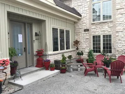 a patio with red chairs and potted plants in front of a house at Grey Rose Suites in Hanover