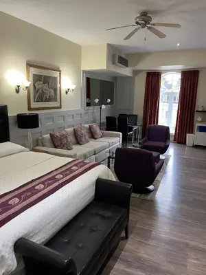 a hotel room with a bed and a couch and chairs at Grey Rose Suites in Hanover