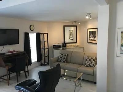 a living room with a couch a table and a desk at Grey Rose Suites in Hanover