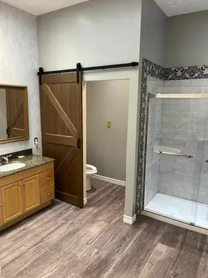 a bathroom with a shower and a glass door at Grey Rose Suites in Hanover