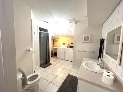 a white bathroom with a toilet and a sink at Leslie in Wasaga Beach