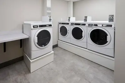 two white washing machines in a laundry room at TownePlace Suites by Marriott Hamilton in Hamilton