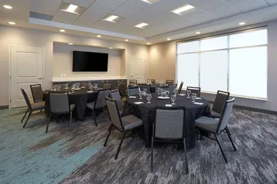 a conference room with tables and chairs and a flat screen tv at TownePlace Suites by Marriott Hamilton in Hamilton