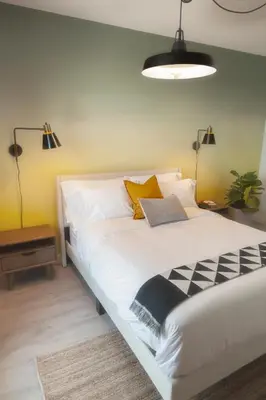a bedroom with a large white bed with yellow walls at The Laundry Rooms - Waterloo in Waterloo