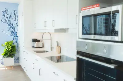 a white kitchen with a sink and a microwave at The Laundry Rooms - Waterloo in Waterloo